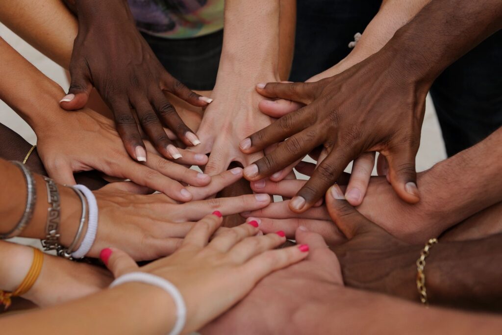 Diverse group joining hands and feet in unity.